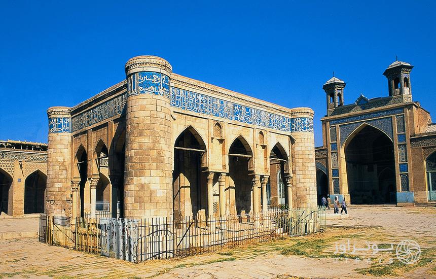 صحن مسجد «عتیق» شیراز که سازه‌ای مکعبی‌اش و آجری در وسط دارد و پشت آن شبستان قرار گرفته‌است. 